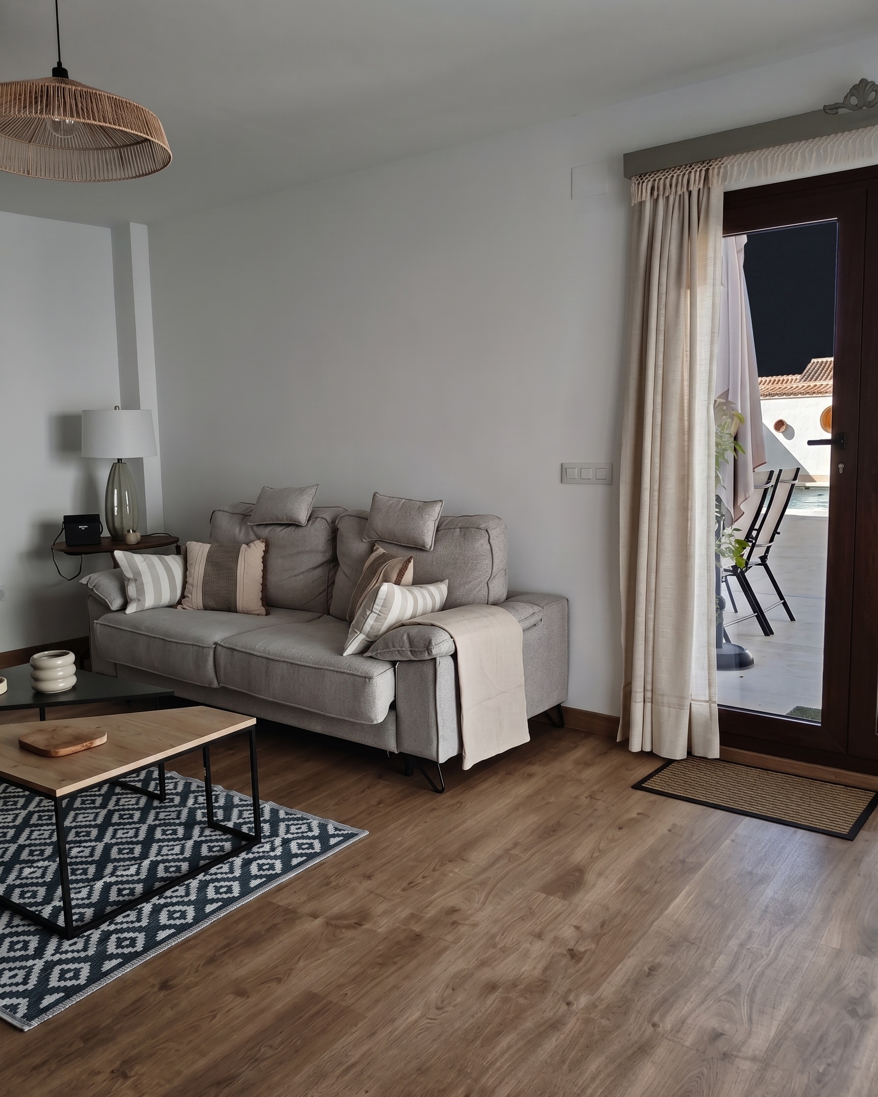 Salón de El Principal con el sofá y la puerta abierta a la terraza