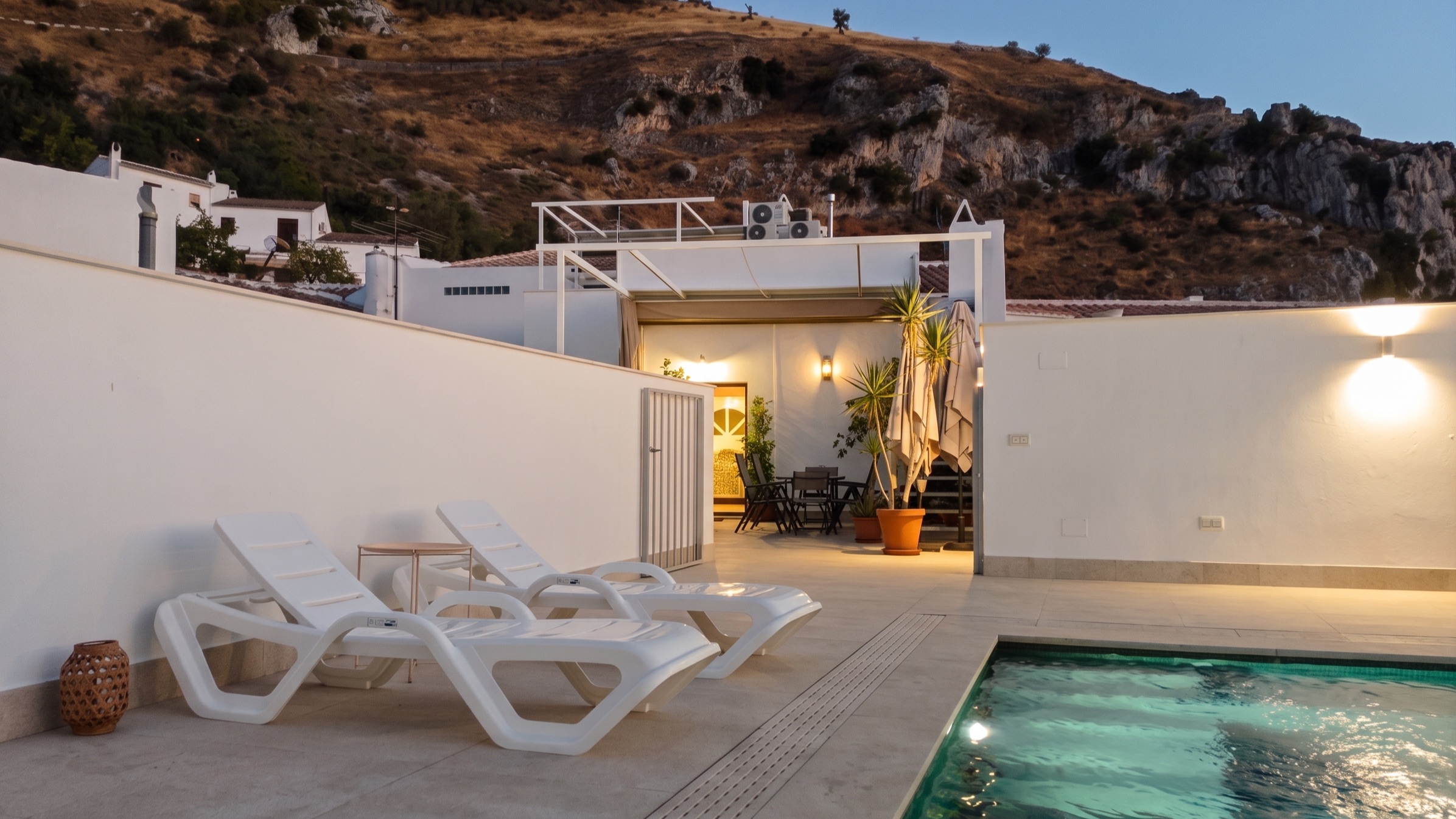 La piscina, la casa y el cerro detrás, en hora azul