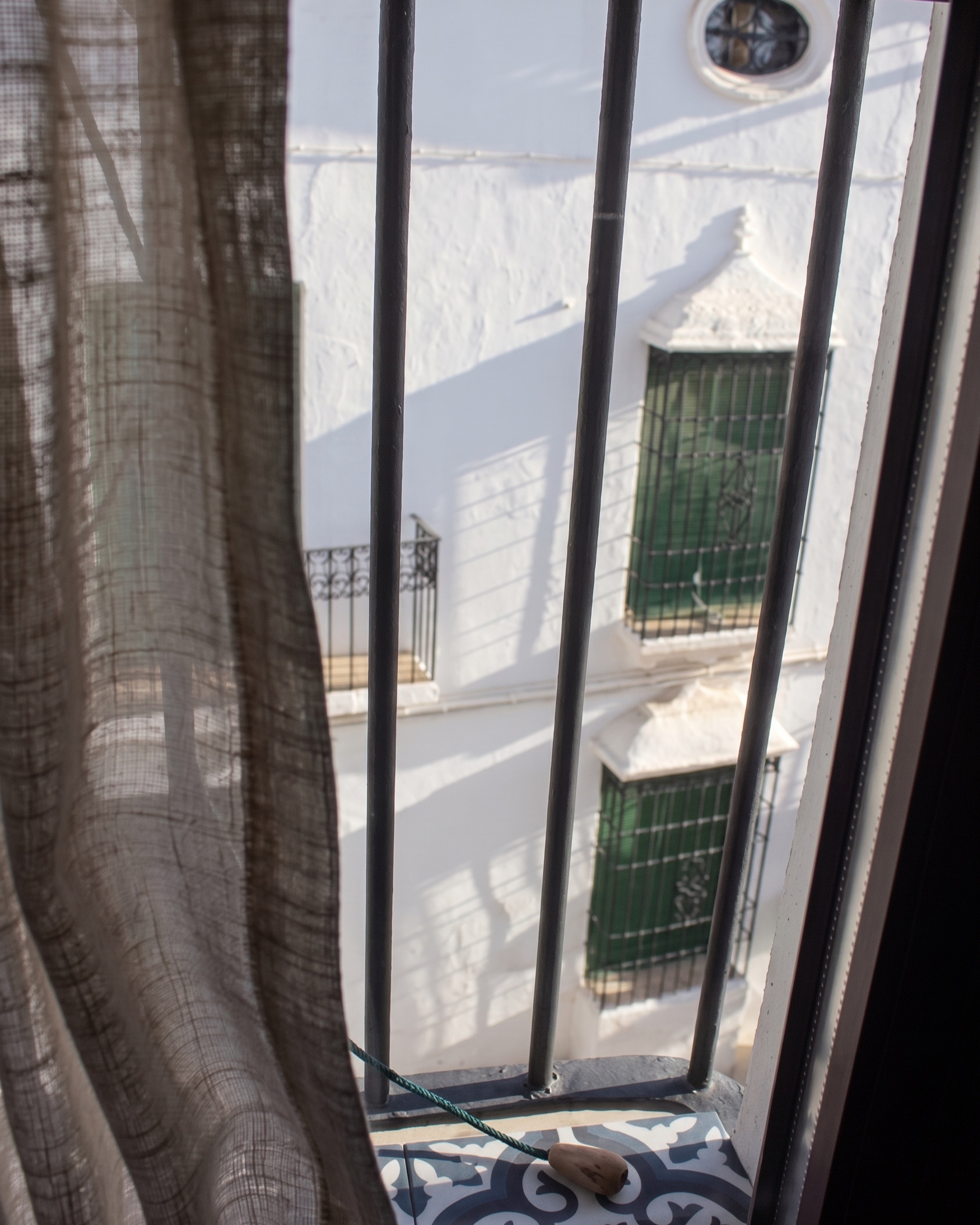 La calle vista a través de la reja del dormitorio del Ático
