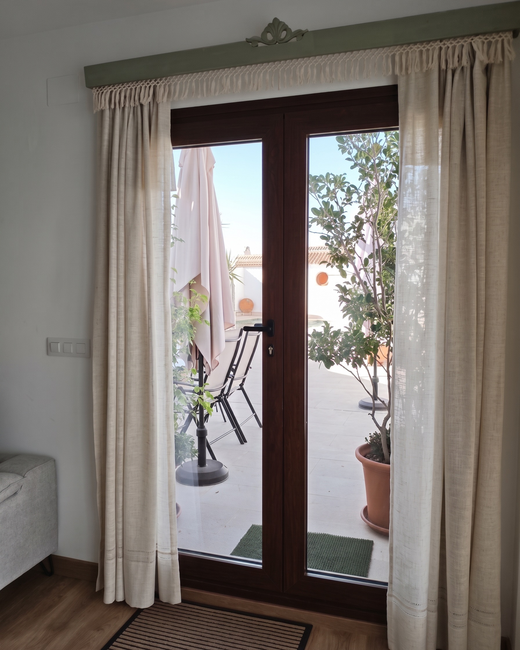 La puerta de la terraza de El Principal, enmarcada por las cortinas de lino