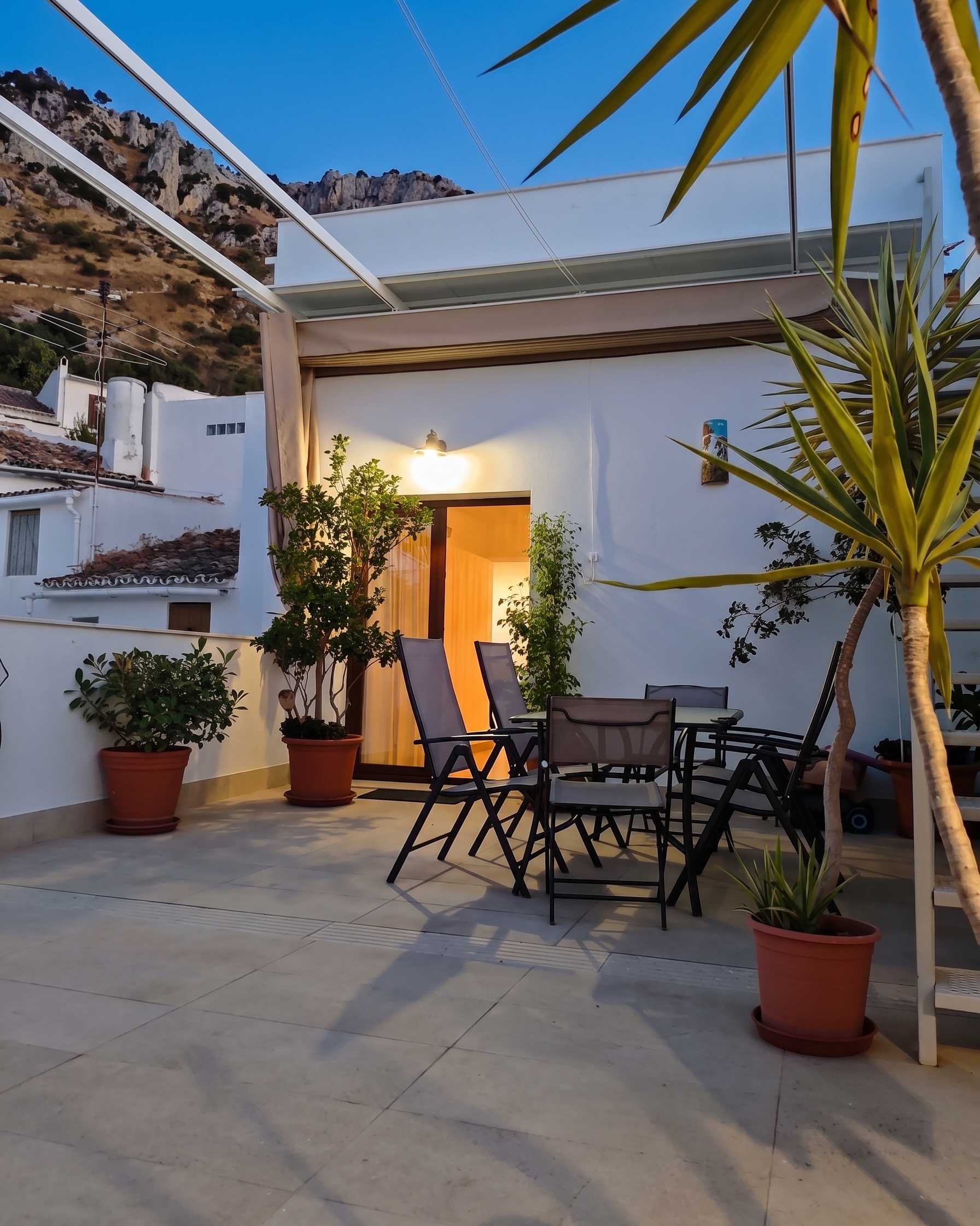 Terraza de El Principal al anochecer, con la roca del cerro detrás