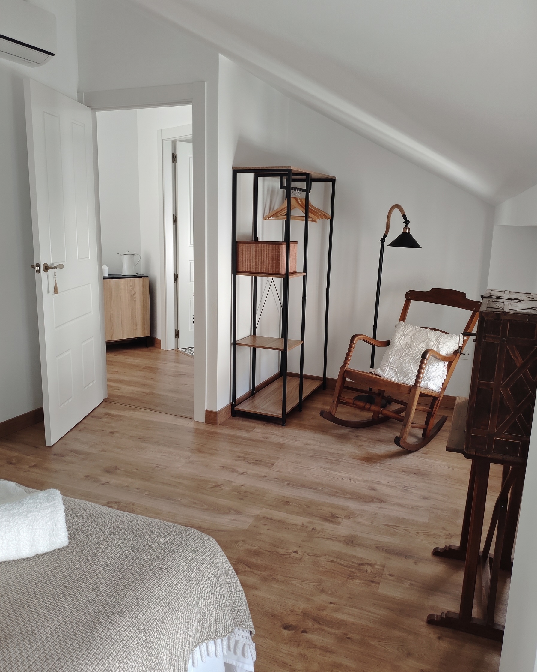 Dormitorio del Ático, con la mecedora y el techo abuhardillado