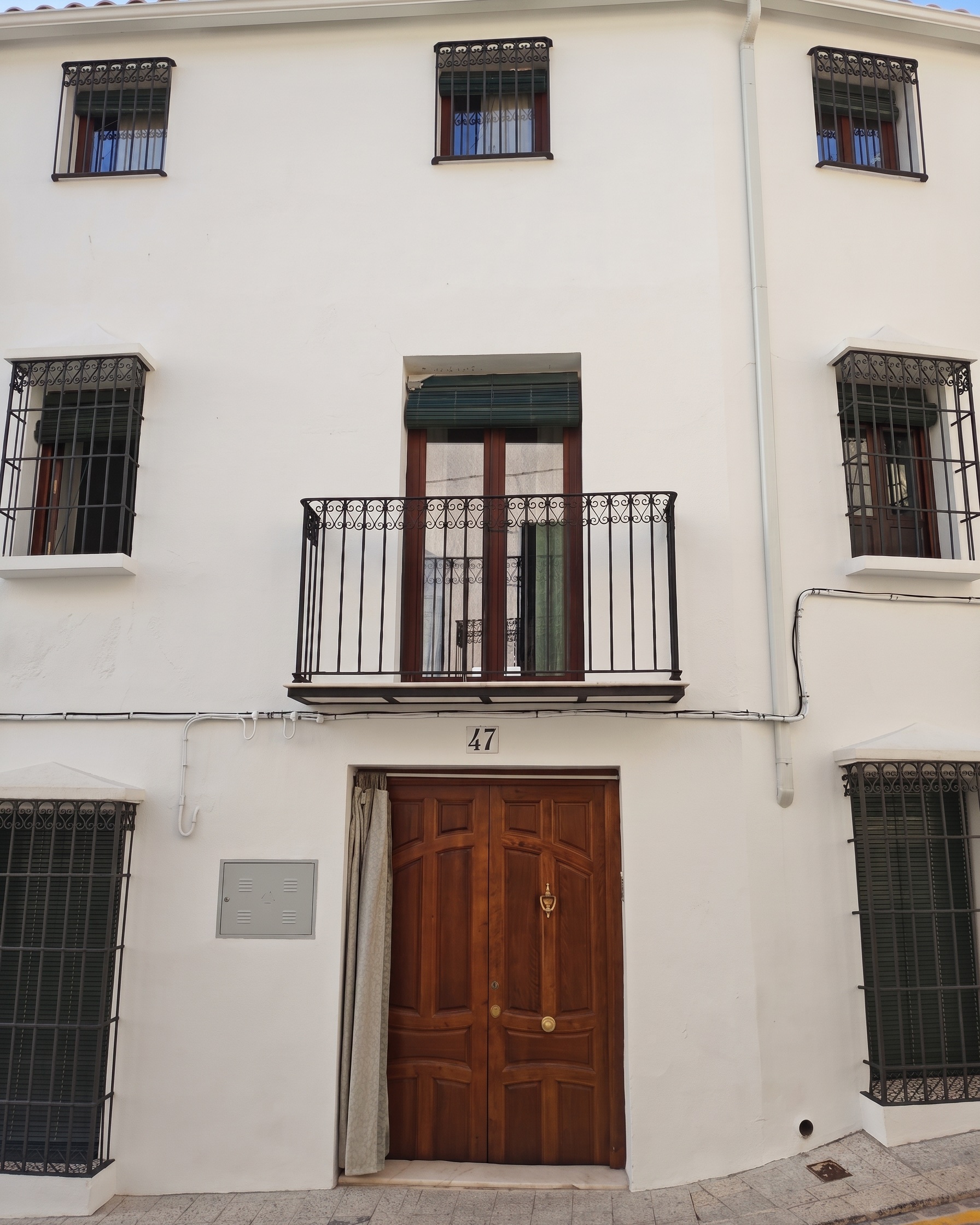 Fachada encalada de La Hoya 47, con el balcón y el número 47 sobre la puerta