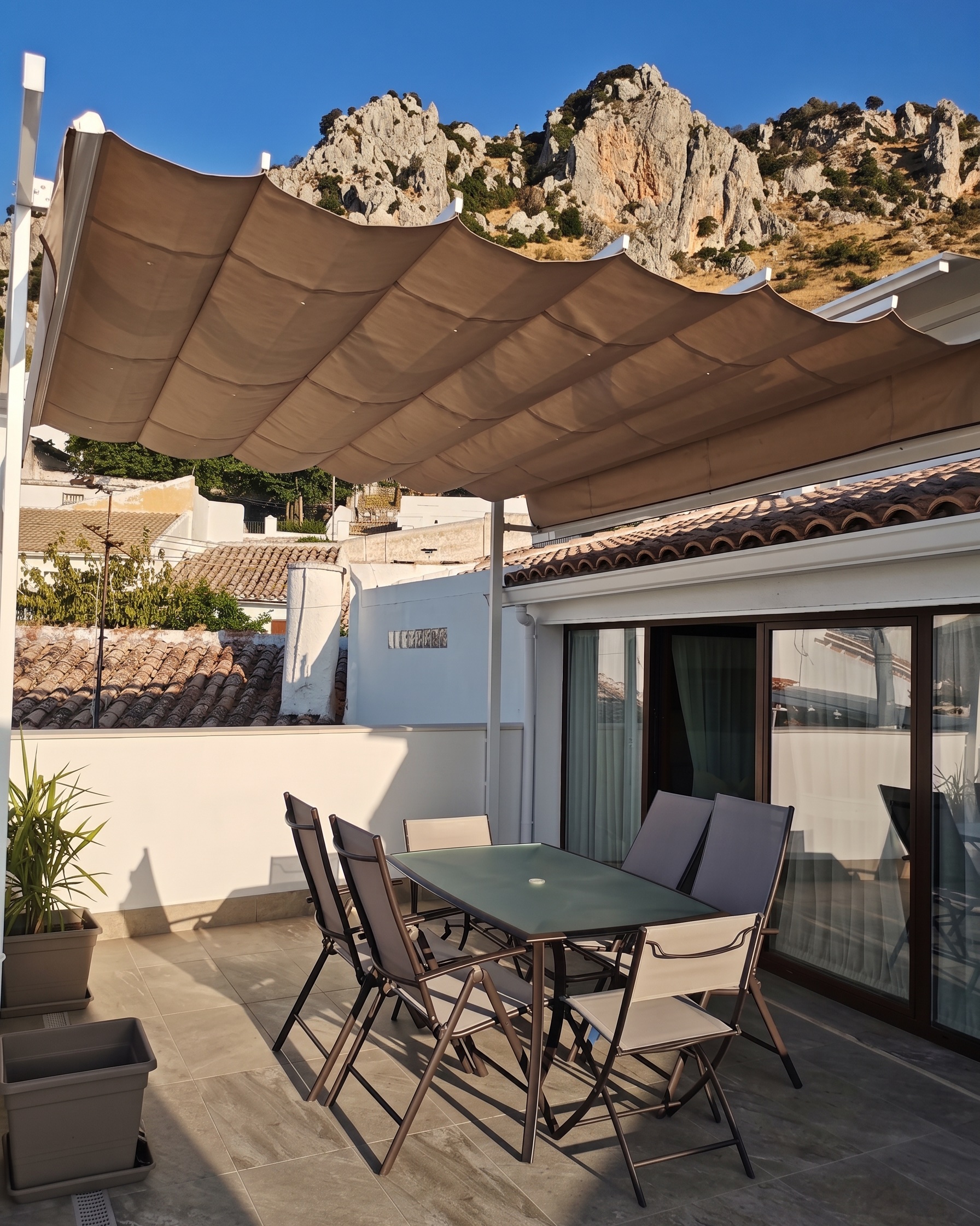 Terraza del Ático bajo el toldo, con la sierra al fondo