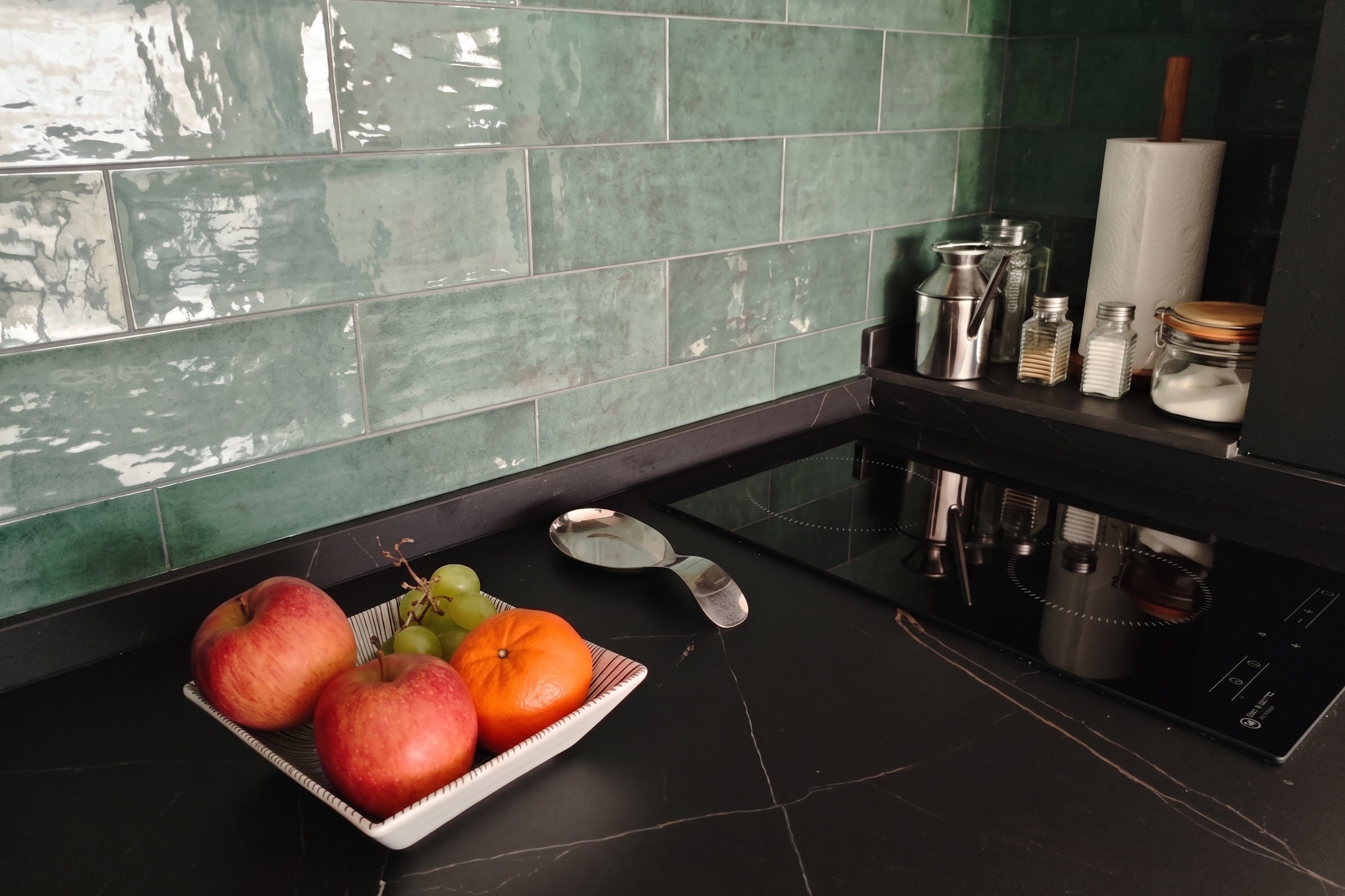 Encimera de la cocina del Ático: fruta, azulejo verde y placa de inducción
