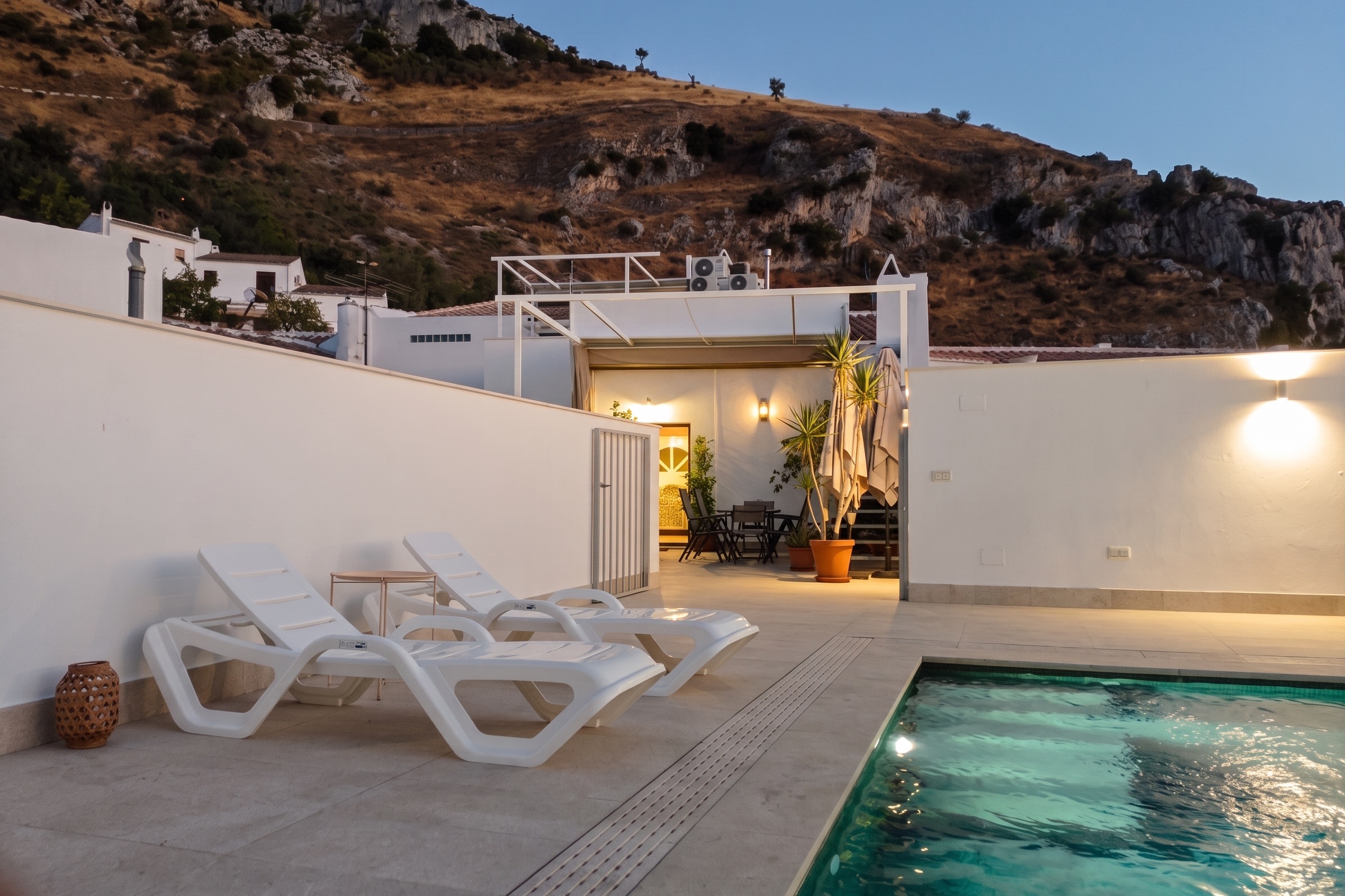 La piscina, la casa y el cerro detrás, en hora azul