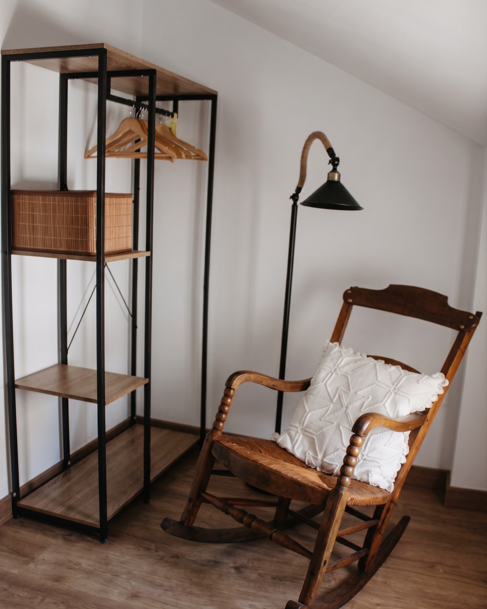 Mecedora de madera y estantería en el dormitorio del Ático
